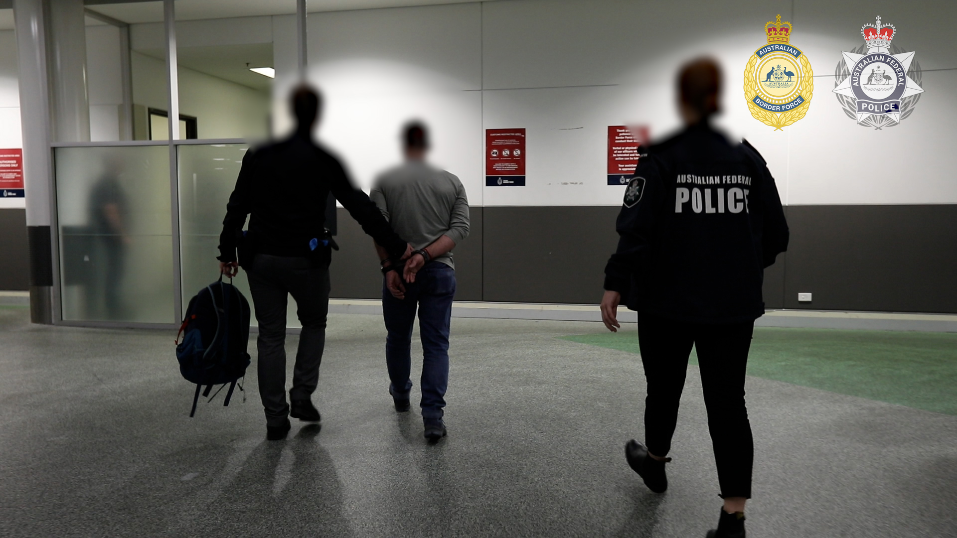 Man in handcuffs escorted by law enforcement